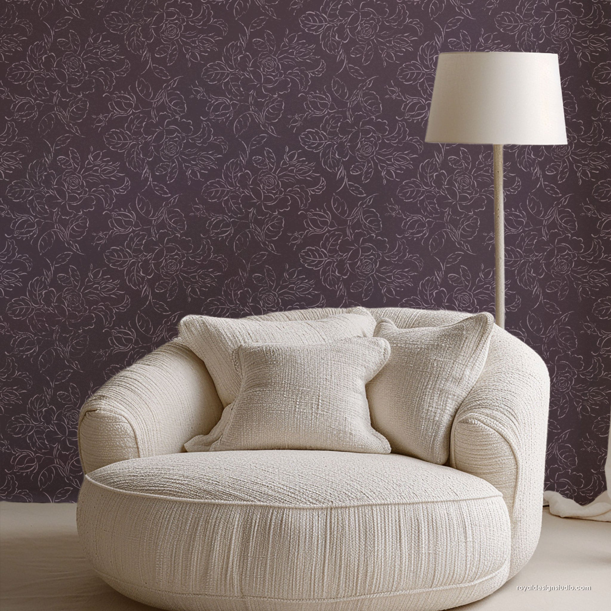 White textured armchair with cushions against a purple floral-patterned wall stenciled with a large scale floral wall stencil design.