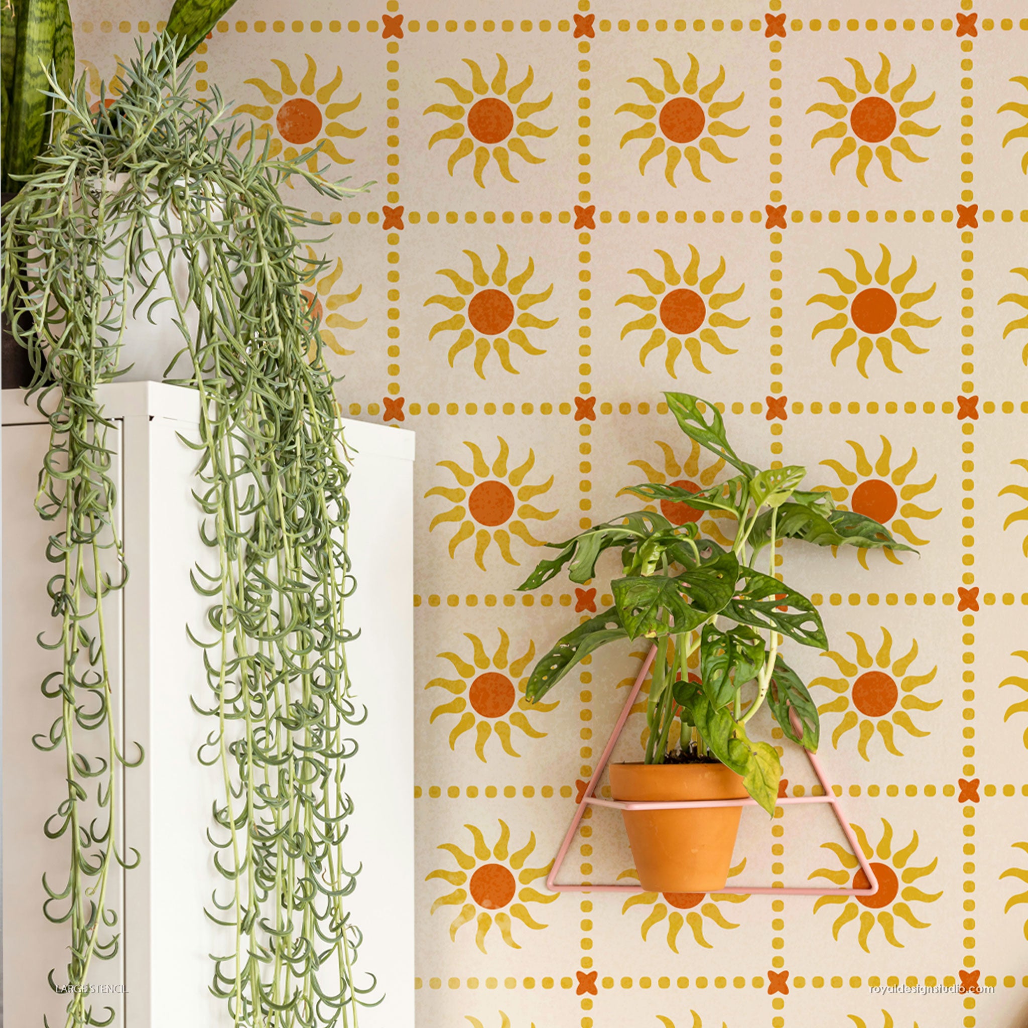 Potted plants against a wall stencil with sun pattern