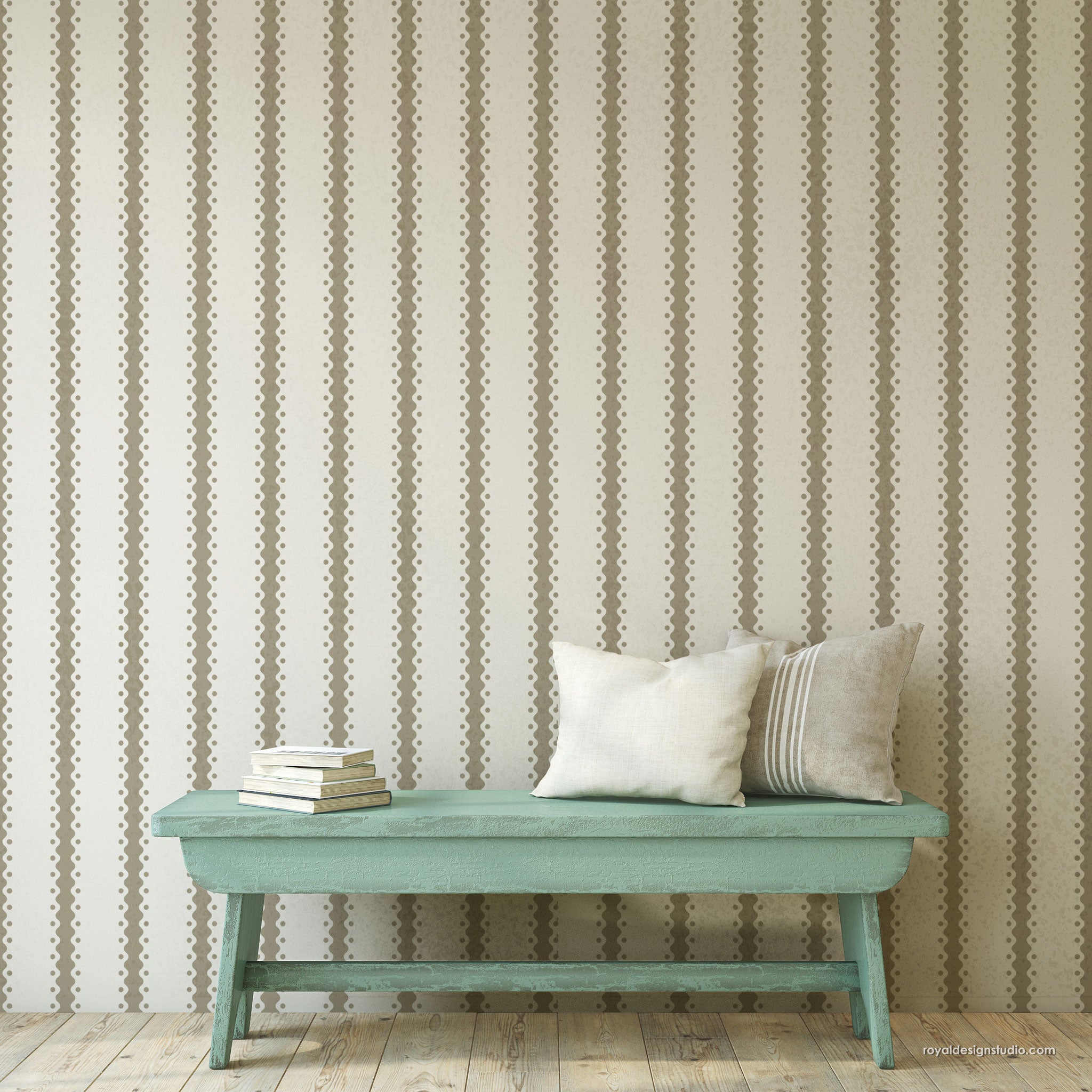 Beige and brown vertically striped wall with a scalloped pattern, styled behind a mint green wooden bench with two cream pillows and a stack of books.