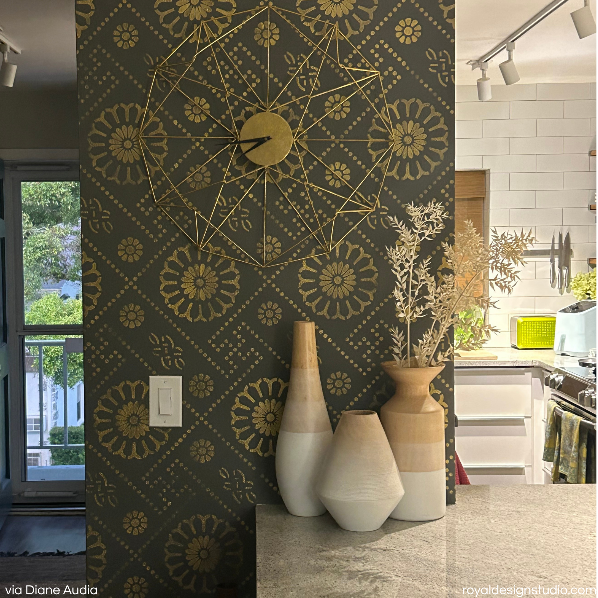 A kitchen wall stenciled in metallic gold with an Asian inspired wall stencil