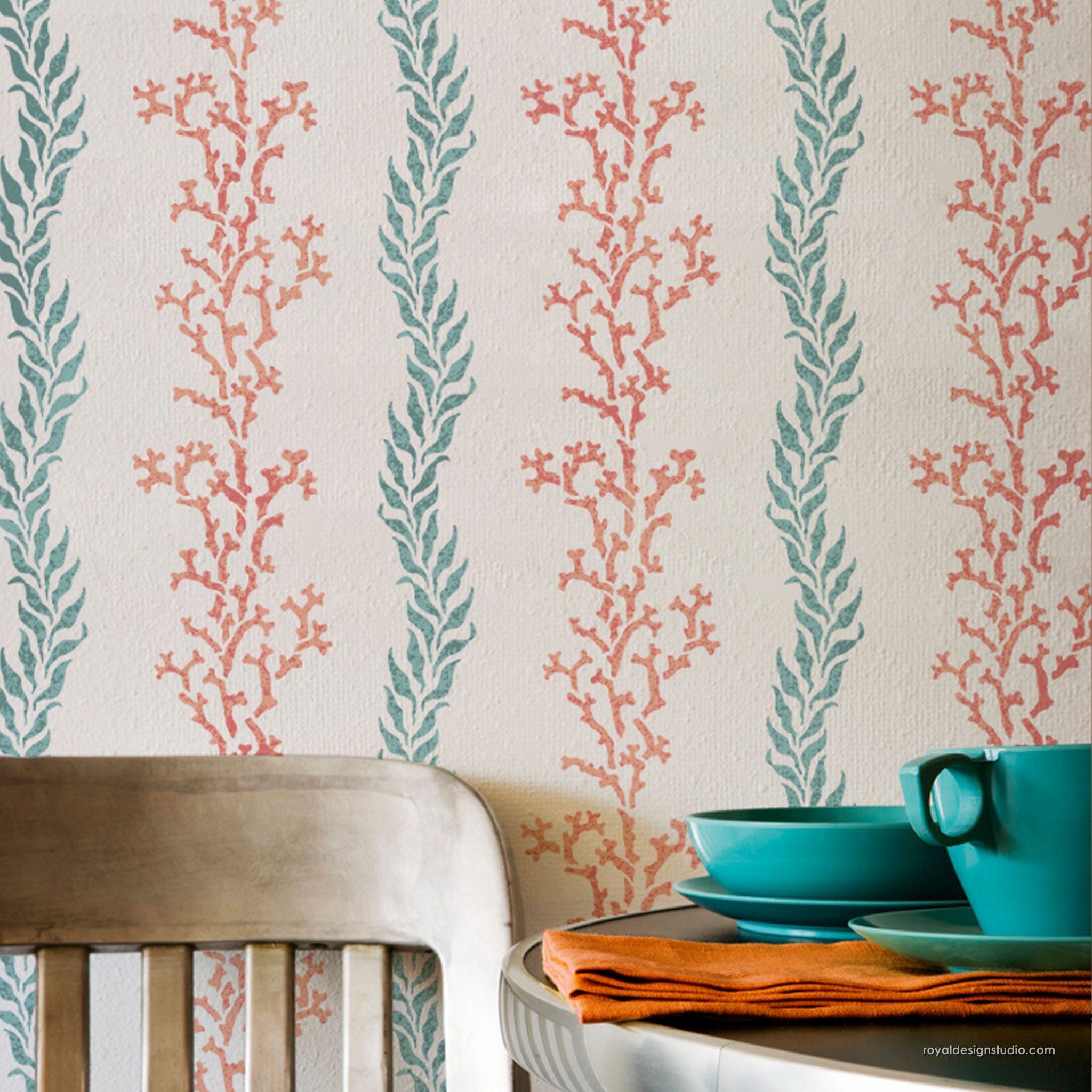 Teal and orange patterned coral stripe wall stencil with a wooden chair and table set.