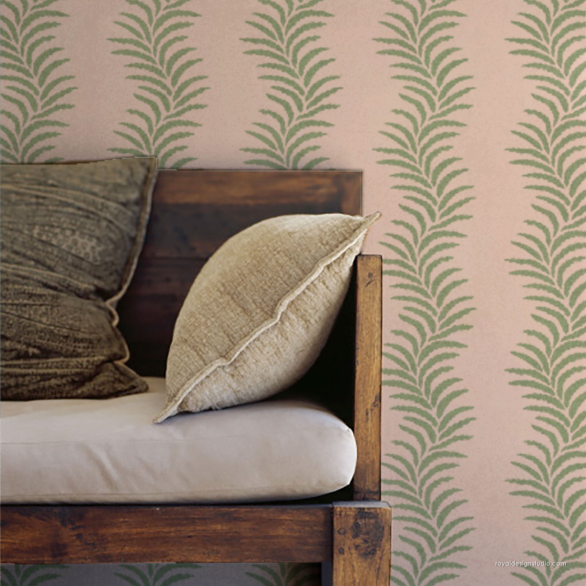 Wooden bench with cushions against a wall with stenciled green leaf pattern