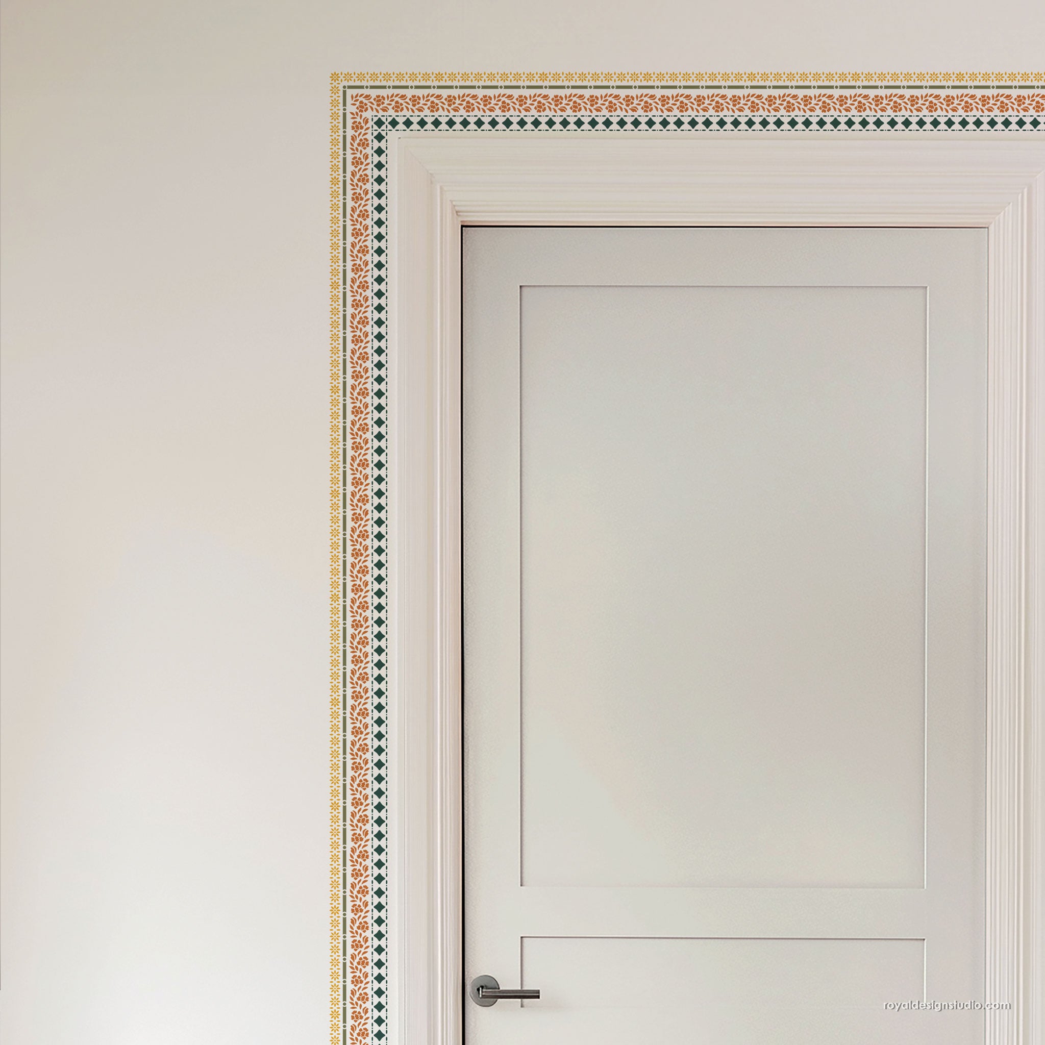 A white interior door with a decorative border pattern in orange, green, and beige along the wall and frame, shown against a light neutral wall.