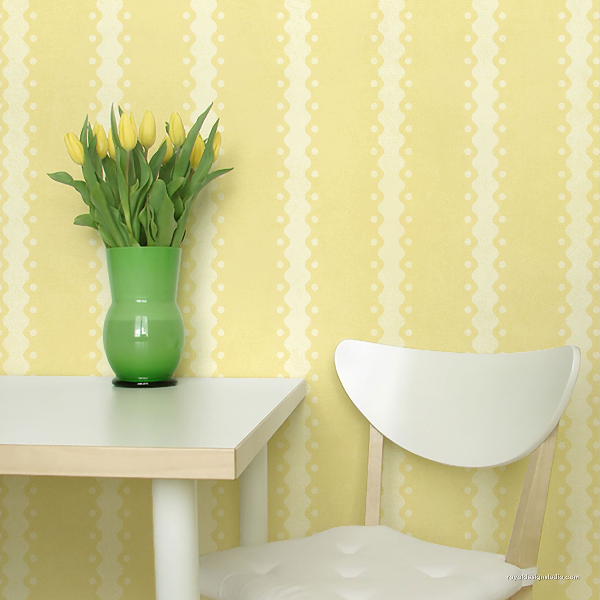 Yellow and white patterned wall in a dining room setting, featuring a white table with a green vase of yellow tulips and a white wooden chair.