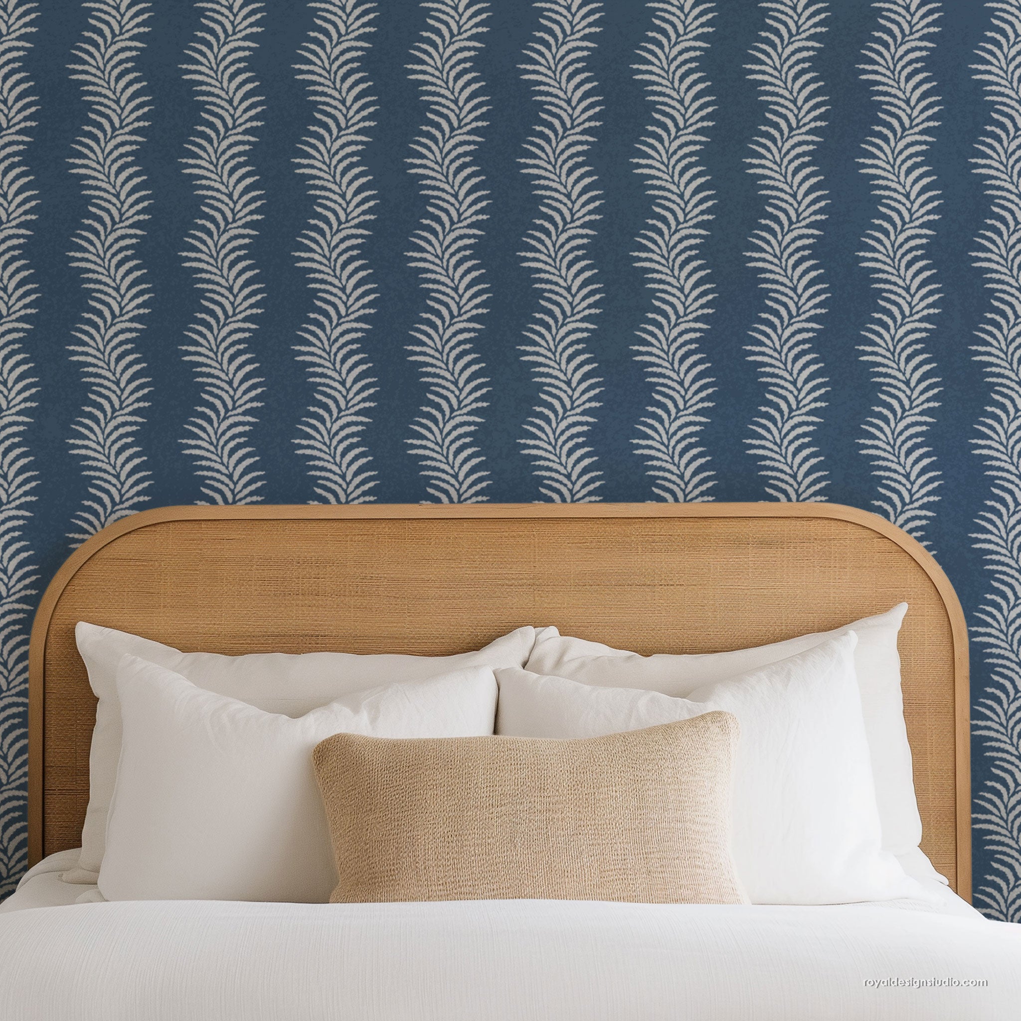 Blue and white coastal wall stencil pattern painted on bedroom wall behind wicker headboard